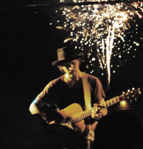 Robbie Lee performing with fireworks in background